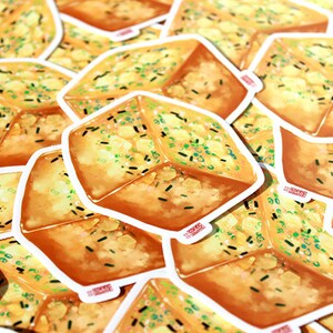 May include: A collection of stickers featuring a square-shaped illustration of a piece of garlic bread. The bread is golden brown with green and black flecks, and a white border. The stickers are scattered across the image.