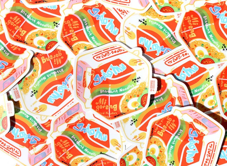 May include: A collection of colorful stickers featuring the Indomie Mi Goreng instant noodle brand. The stickers are designed with a rainbow gradient and feature the brand's logo and product name in a stylized font. The stickers are perfect for adding a touch of fun and personality to laptops, water bottles, or other surfaces.