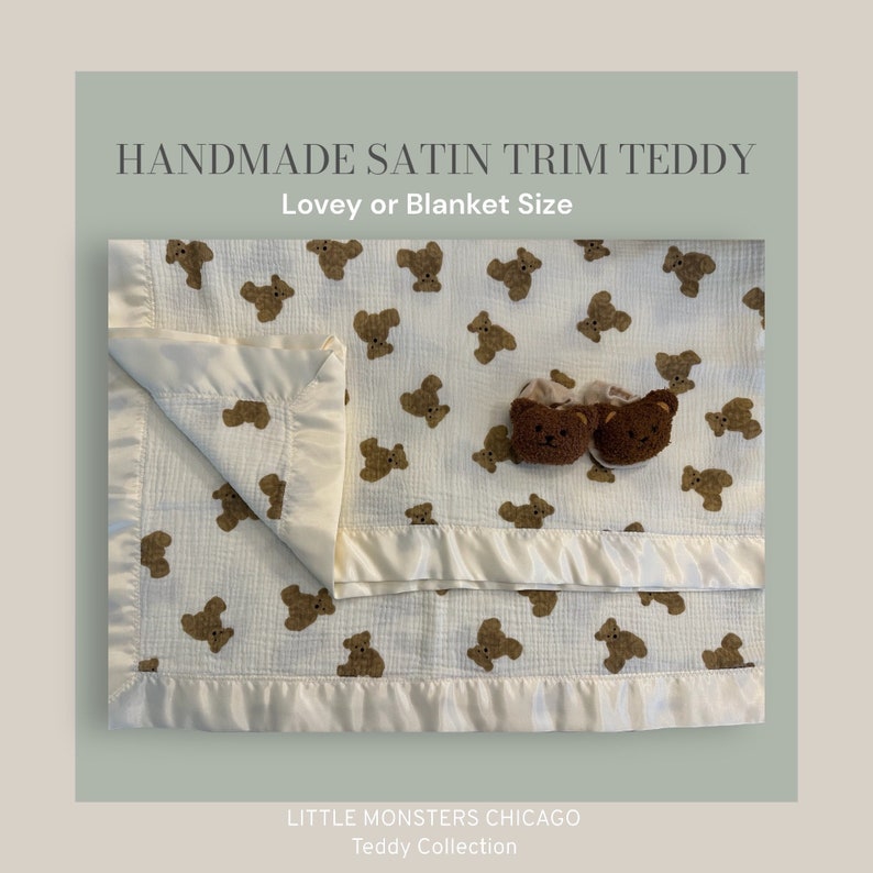 May include: A white muslin baby blanket with a satin trim and a brown teddy bear print. The blanket is folded in half and has a pair of brown teddy bear slippers on top. The text "HANDMADE SATIN TRIM TEDDY" and "Lovey or Blanket Size" is at the top of the image. The text "LITTLE MONSTERS CHICAGO" and "Teddy Collection" is at the bottom of the image.