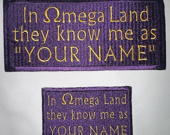 May include: Two purple embroidered patches with gold thread. The top patch reads "In Omega Land they know me as "YOUR NAME"". The bottom patch reads "In Omega Land they know me as YOUR NAME".