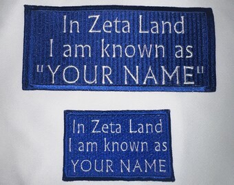 May include: Two blue embroidered patches with white text. The top patch reads "In Zeta Land I am known as "YOUR NAME"". The bottom patch reads "In Zeta Land I am known as YOUR NAME".