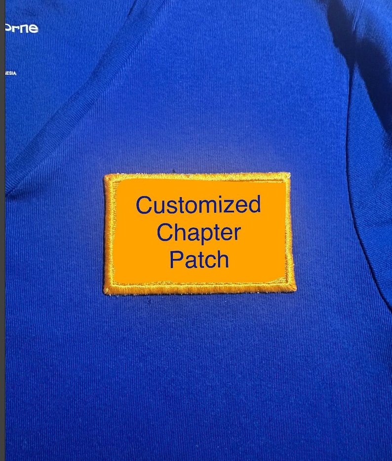 May include: A blue shirt with a rectangular, orange patch. The patch has gold stitching around the edges and the words "Customized Chapter Patch" in dark blue text.