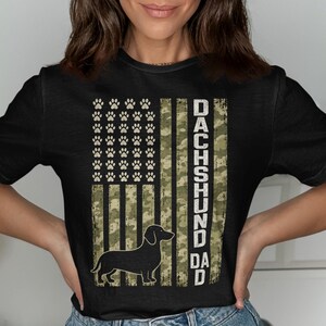 Black t-shirt with American flag design featuring paw prints and a dachshund silhouette.