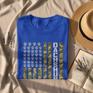 Blue t-shirt with distressed US flag design featuring paw prints and "DACHSHUN" text.