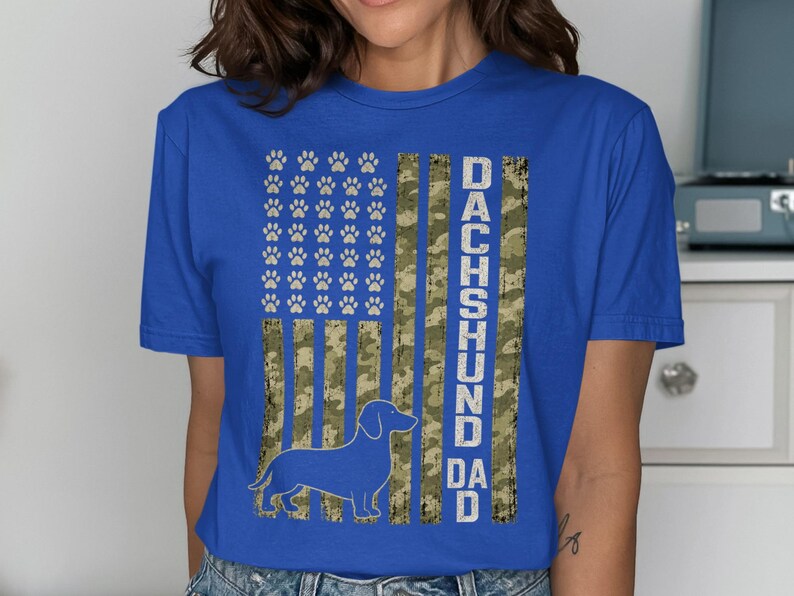Blue t-shirt with "Dachshund Dad" text and a dachshund silhouette on a camouflage flag.