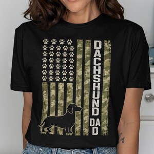 Black t-shirt with distressed American flag graphic featuring paw prints and a dachshund silhouette.