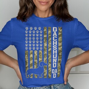 Blue shirt with a Dachshund silhouette and "Dachshund Dad" text on a flag design.
