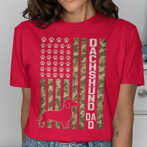 Red t-shirt with a distressed US flag design featuring paw prints and a dachshund silhouette.