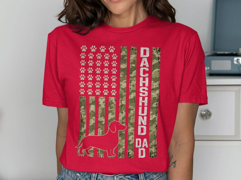 Red t-shirt with a distressed US flag design featuring paw prints and a dachshund silhouette.