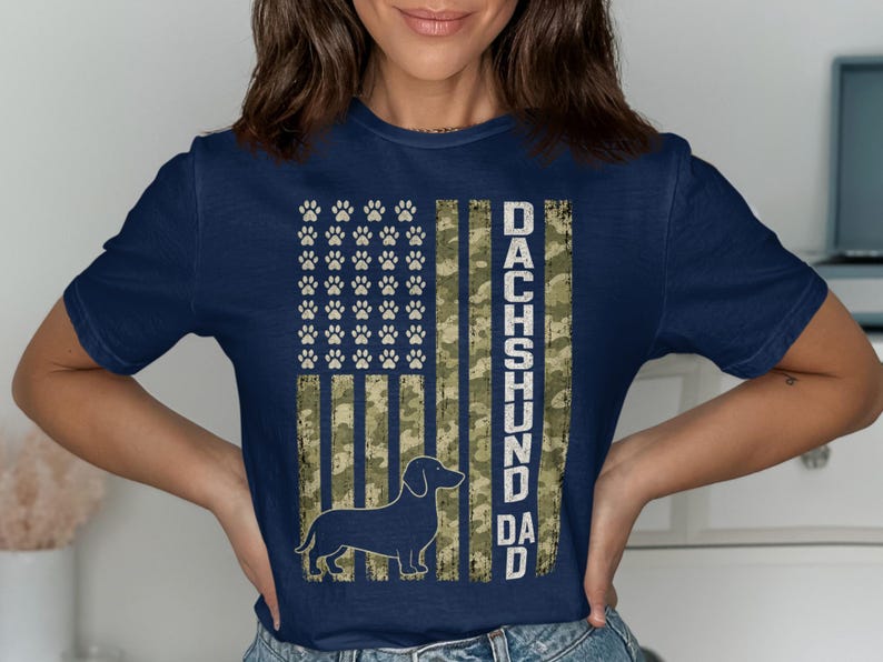 Dark blue t-shirt with camouflage flag and dachshund silhouette, reads "DACHSHUND DAD".
