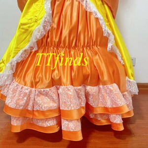 May include: A long orange and yellow dress with white lace trim. The dress has multiple layers and a gathered skirt. The text "TTfinds" is visible on the dress.