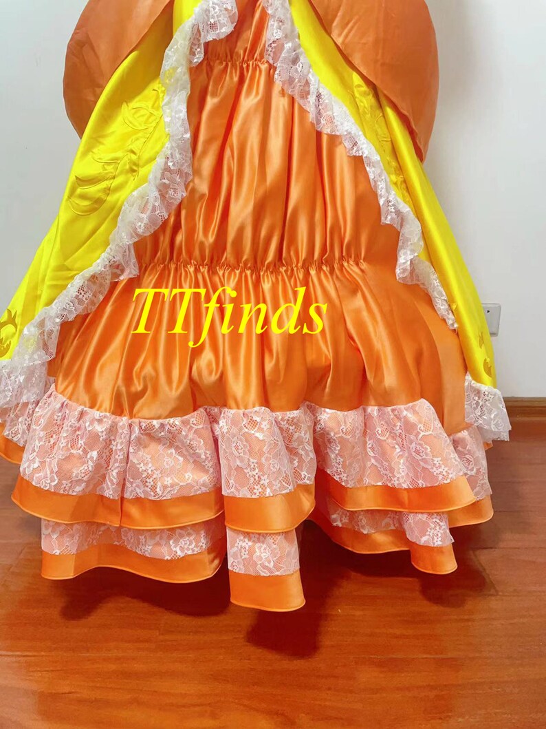 May include: A long orange and yellow dress with white lace trim. The dress has multiple layers and a gathered skirt. The text "TTfinds" is visible on the dress.