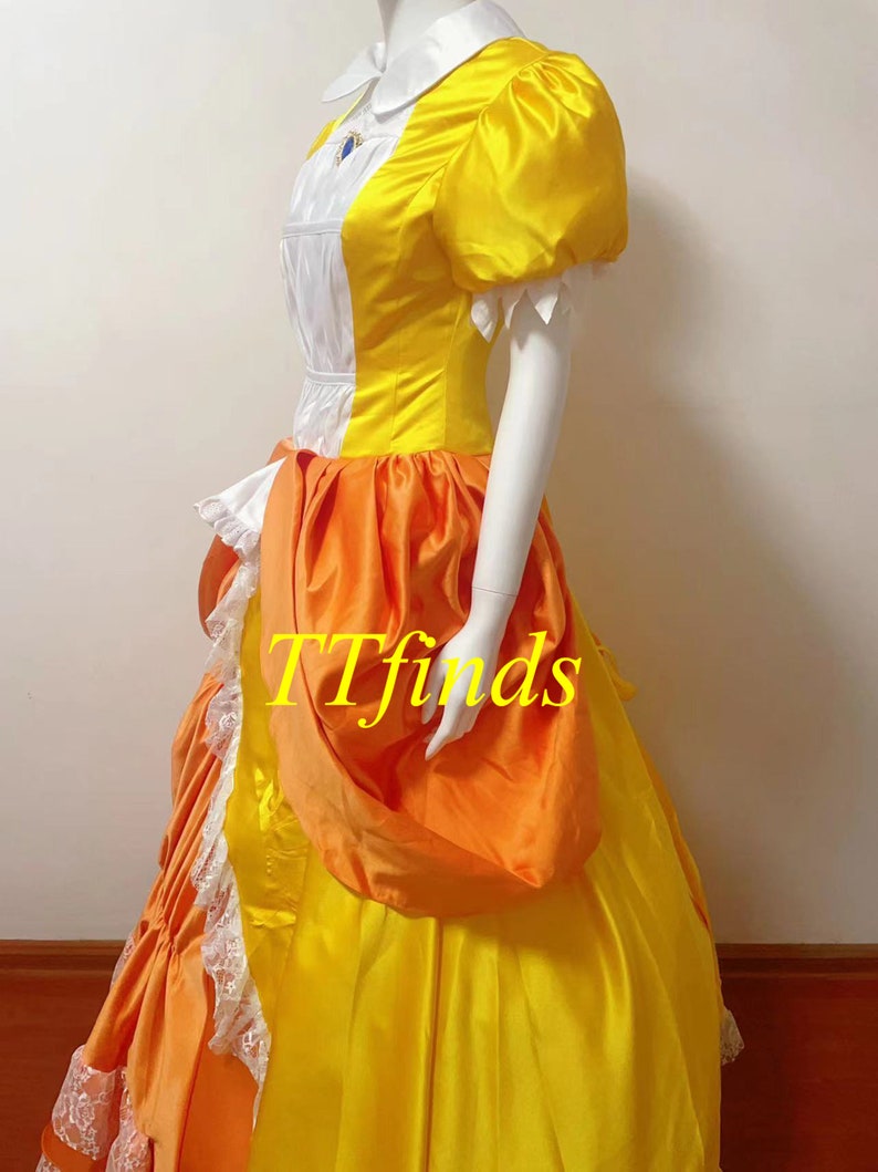May include: A yellow and orange dress with a white collar and puffed sleeves. The dress has a large orange bow on the side and a white lace trim at the bottom.