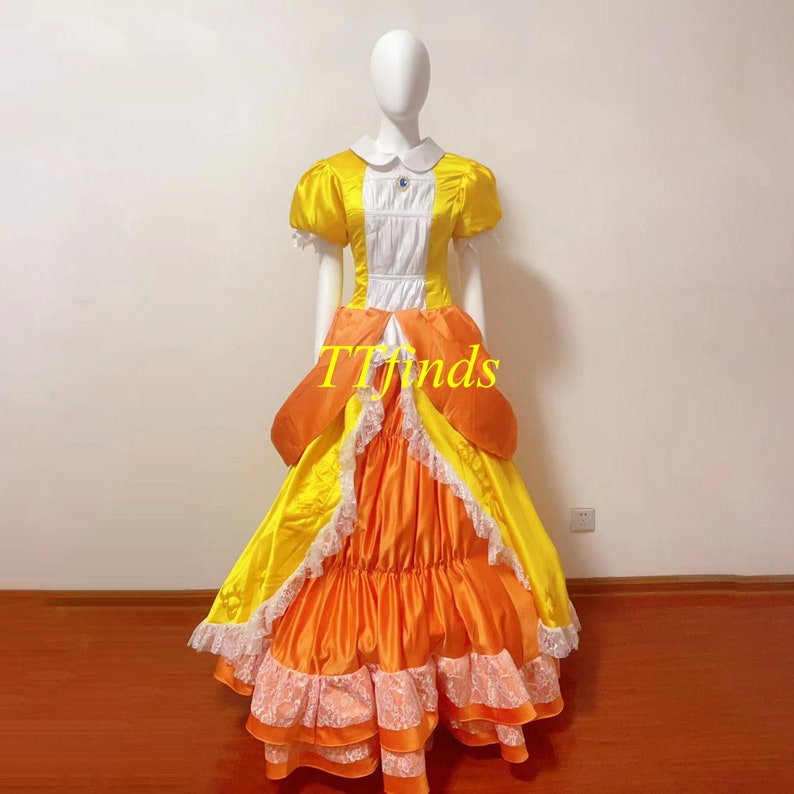 May include: A yellow and orange princess costume with a white bodice and lace trim. The dress has a full skirt and puffed sleeves.