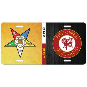 May include: Rectangular license plate featuring two distinct designs. The left side displays a gold star with various symbols on a yellow and orange gradient background. The right side has a red circle with the words "HEROINES OF JERICHO" and a white illustration.