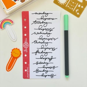 May include: A sheet of white paper with black handwritten text listing the days of the week, "Monday", "Tuesday", "Wednesday", "Thursday", "Friday", "Saturday", and "Sunday". Each day of the week is followed by the word "hooray" written in cursive.