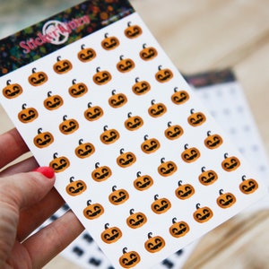 Peut inclure: Une feuille d'autocollants avec de nombreux visages de citrouille orange sur un fond blanc. Les autocollants sont dispos&eacute;s en rang&eacute;es et en colonnes. La feuille est &eacute;tiquet&eacute;e "Sticker Kitten".