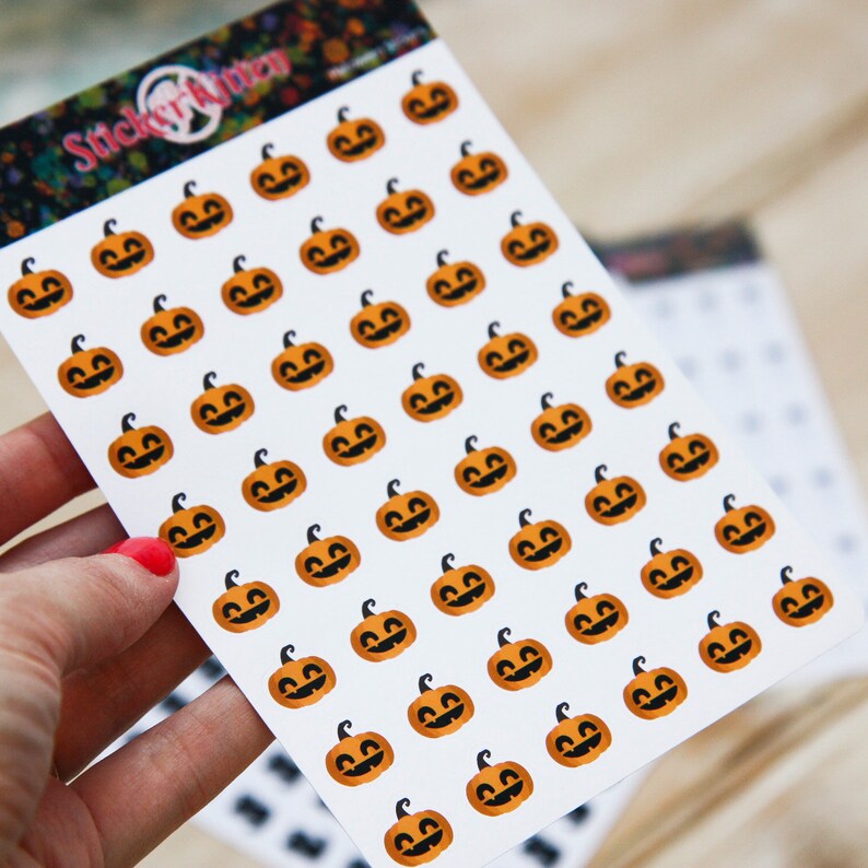 Peut inclure: Une feuille d'autocollants avec de nombreux visages de citrouille orange sur un fond blanc. Les autocollants sont dispos&eacute;s en rang&eacute;es et en colonnes. La feuille est &eacute;tiquet&eacute;e "Sticker Kitten".