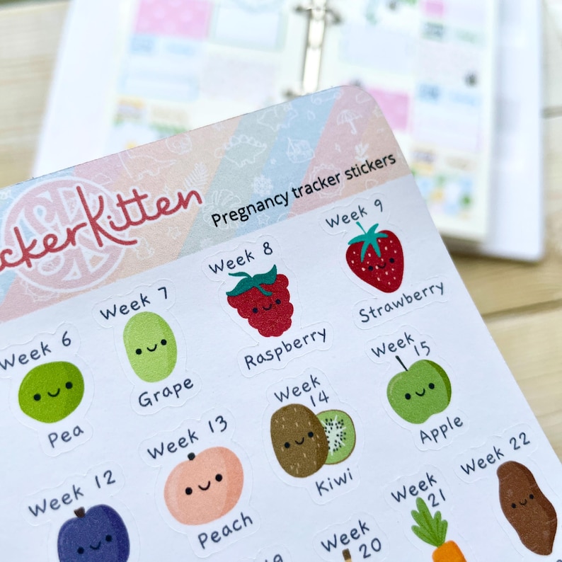 Puede incluir: Pegatinas de seguimiento del embarazo con ilustraciones de frutas lindas. Cada pegatina presenta una fruta diferente con una cara sonriente y el n&uacute;mero de semana correspondiente. Las pegatinas est&aacute;n impresas en papel blanco con un fondo colorido.