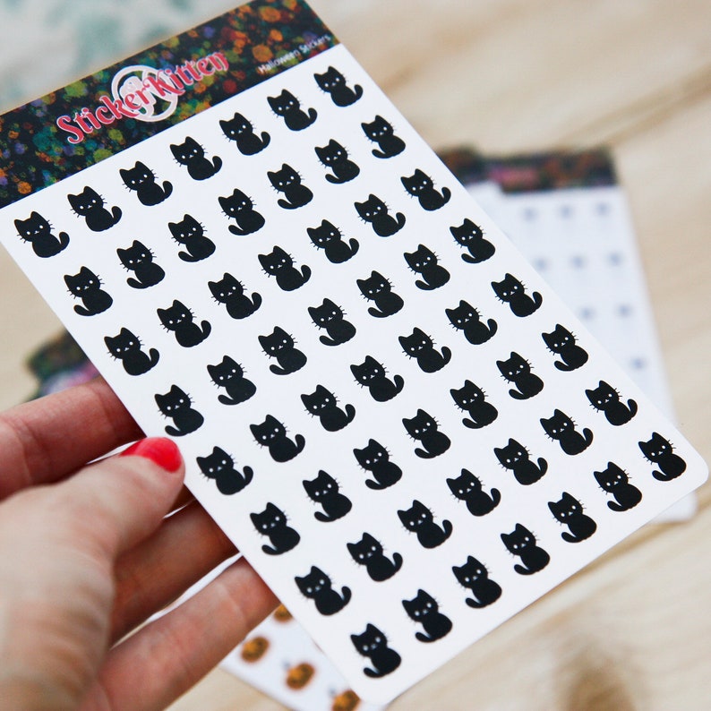May include: A sheet of black cat stickers on a white background. The sheet is labeled "Sticker Kitten" and "Halloween Stickers".
