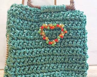 Borsa mini bag in rafia verde bottiglia, con tasca interna, manici di legno, decorata con cuore di cristalli colorati