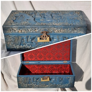 May include: A blue wooden box with intricate carvings and a red velvet lining. The box has a brass latch and hinges.
