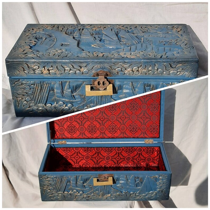 May include: A blue wooden box with intricate carvings and a red velvet lining. The box has a brass latch and hinges.