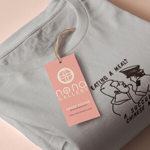 An embroidered light grey t-shirt design of the Australian Jack Karlson being arrested while he shouts Eating A Meal? A Succulent Chinese Meal?!