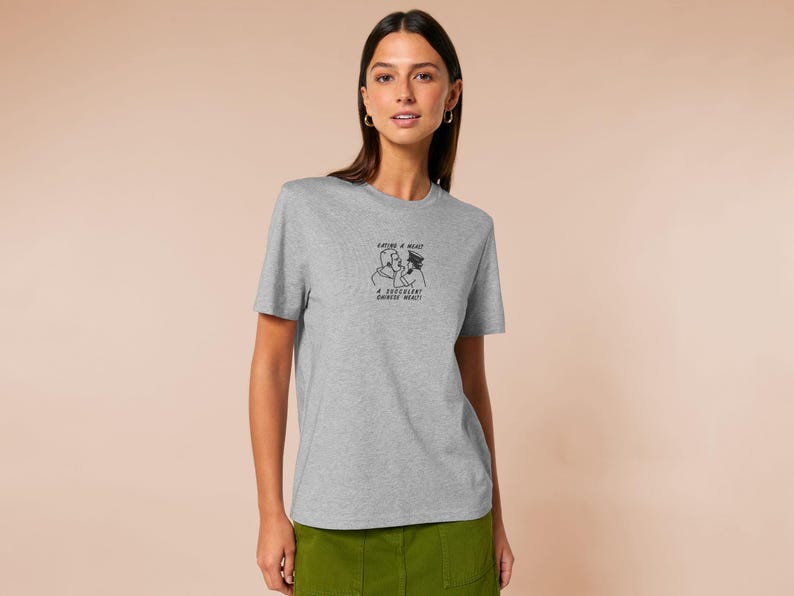 An embroidered light grey t-shirt design of the Australian Jack Karlson being arrested while he shouts Eating A Meal? A Succulent Chinese Meal?!
