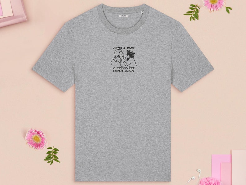 An embroidered light grey t-shirt design of the Australian Jack Karlson being arrested while he shouts Eating A Meal? A Succulent Chinese Meal?!