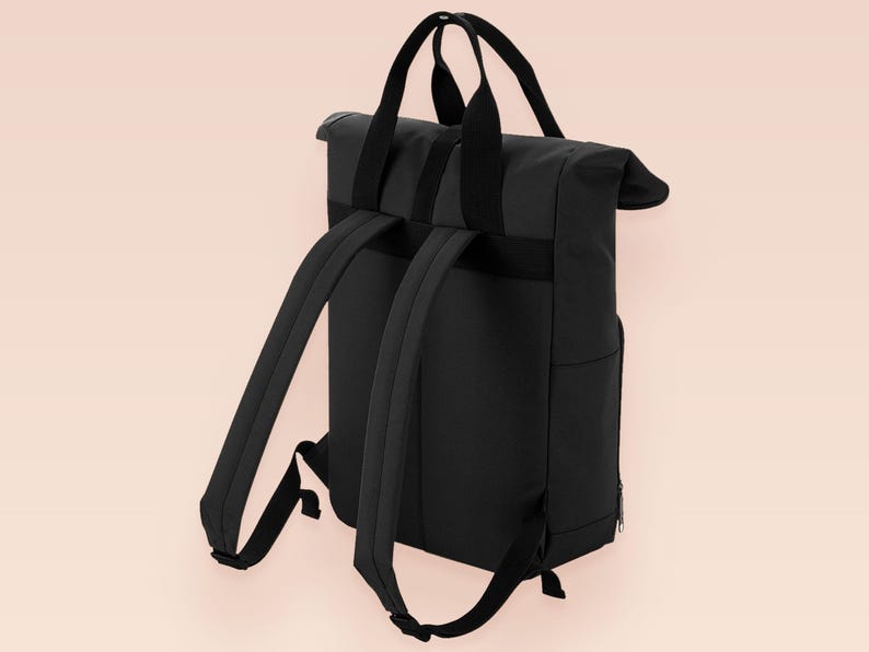 Black roll top backpack with a front pocket and an embroided mothman cryptid design with the lext live lamp lurk