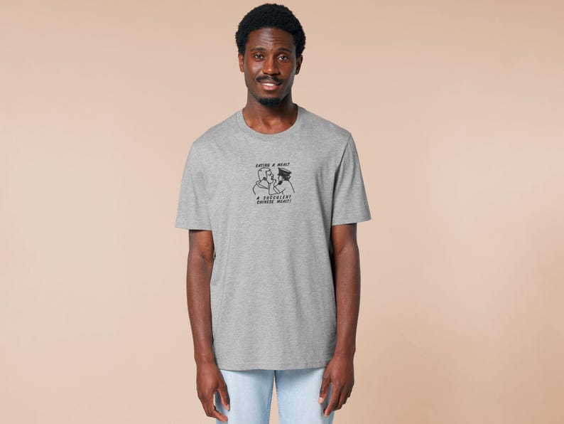 An embroidered light grey t-shirt design of the Australian Jack Karlson being arrested while he shouts Eating A Meal? A Succulent Chinese Meal?!