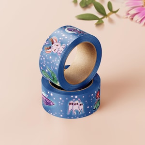 Op de afbeelding: Twee rollen blauwe washi tape met een ruimtethema. De tape heeft illustraties van aliens, sterren en andere hemellichamen.