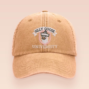May include: A tan baseball cap with the embroidered text "SILLY GOOSE UNIVERSITY". The cap has a curved peak and an adjustable strap. The logo is a goose wearing a graduation cap.