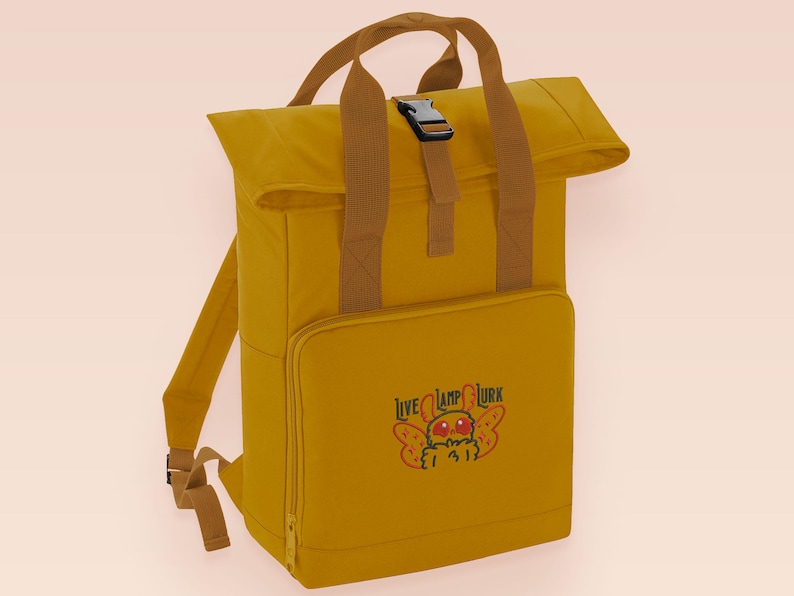 Yellow roll top backpack with a front pocket and an embroided mothman cryptid design with the lext live lamp lurk