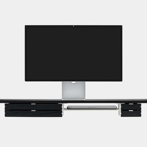 May include: A black computer monitor with a silver stand sits on a black desk with two sets of drawers. A silver laptop is placed on the desk. The desk is a modern design.