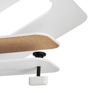 May include: Close-up of a white desk organizer with a cork surface and a black adjustable clamp. The design features clean lines and a minimalist aesthetic, suitable for home or office use.