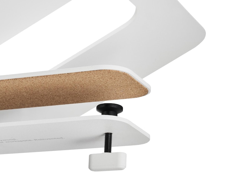 May include: Close-up of a white desk organizer with a cork surface and a black adjustable clamp. The design features clean lines and a minimalist aesthetic, suitable for home or office use.
