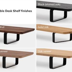 May include: Four different wood finishes for a desk shelf. The finishes are black (stained oak), solid walnut, solid oak, and oak veneer.