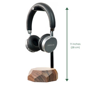 May include: A black and silver headphone stand with a wooden base. The stand is 11 inches (28 cm) tall and features the brand name "SATECHI".