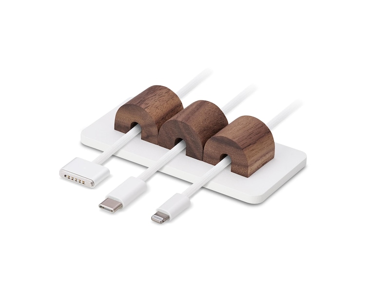 May include: A white cable tidy with three white cables and three brown wooden cable holders. The cable tidy has a rectangular base and is designed to hold various types of charging cables.