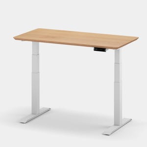 May include: A white electric standing desk with a light wood top. The desk has a control panel on the side of the top.