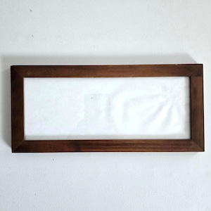 May include: A rectangular wooden picture frame with a dark brown finish. The frame has a white interior and is empty. The frame is displayed against a white background.