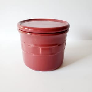 May include: A white ceramic mug with a black handle and the text "But First, Coffee" in a handwritten style. The mug is on a white surface. The mug is approximately 4 inches tall.