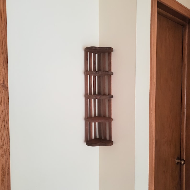May include: A wooden corner shelf with four shelves. The shelf is stained a dark brown color and has a rustic look.