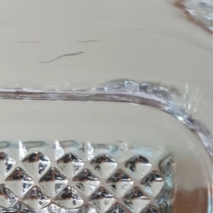 May include: Close-up of a clear glass bowl with a diamond-shaped pattern on the bottom.