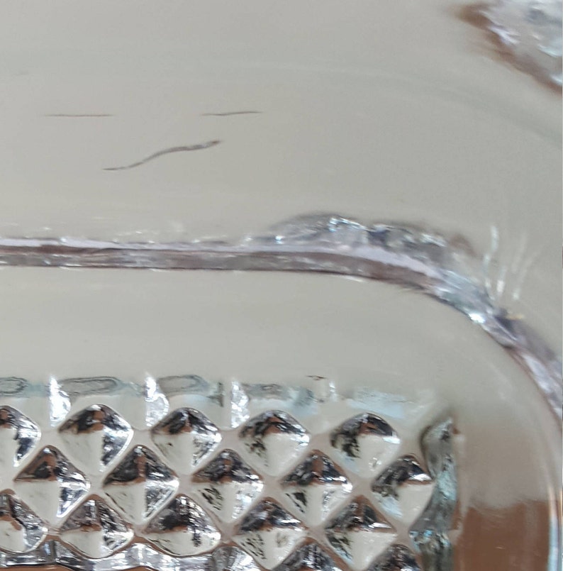 May include: Close-up of a clear glass bowl with a diamond-shaped pattern on the bottom.