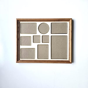 May include: A rectangular wooden picture frame with a medium brown wood grain finish. The frame contains a white mat board with nine varied openings for photographs, including one circular, two square, and six rectangular cutouts.