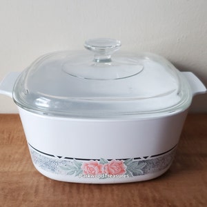 May include: White square baking dish with a glass lid. The dish has a floral design with pink roses and green leaves on a gray background. The text "Parkwood Treasures" is printed on the bottom of the dish.
