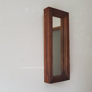 May include: A rectangular, wooden framed mirror with a dark brown finish. The mirror is long and narrow, mounted on a white wall. The frame has a detailed, layered design. The Etsy shop name "ParkwoodTreasures" is visible in the lower left corner.